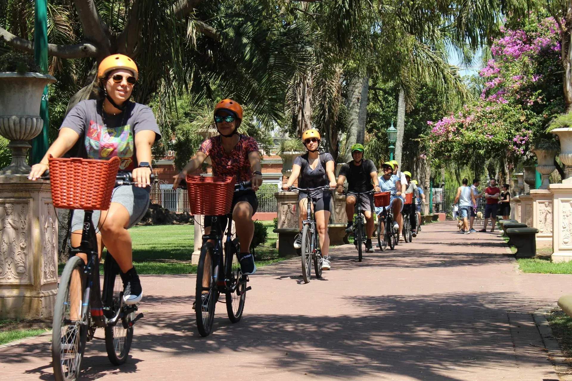 Cyclists riding along a leafy avenue in Buenos Aires.
